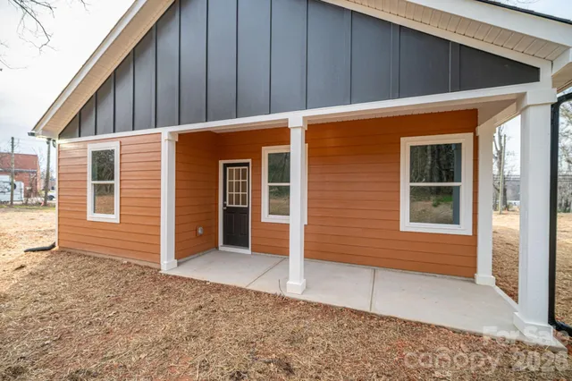 a backyard of a house with table and chairs