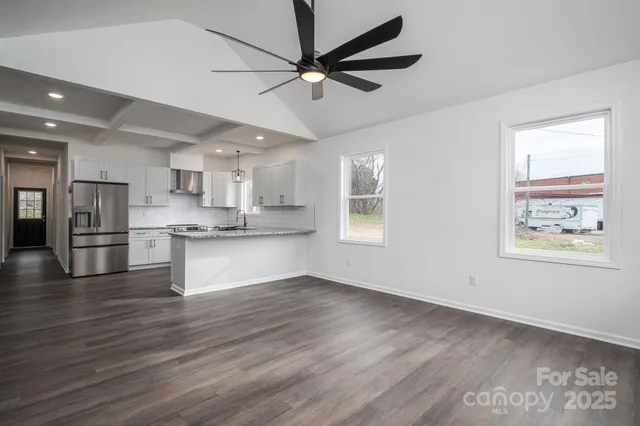 a view of kitchen with stainless steel appliances wooden floor