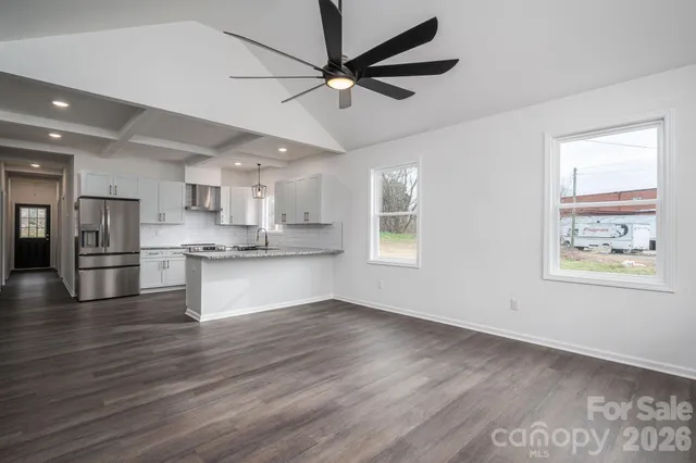 a view of kitchen with stainless steel appliances wooden floor
