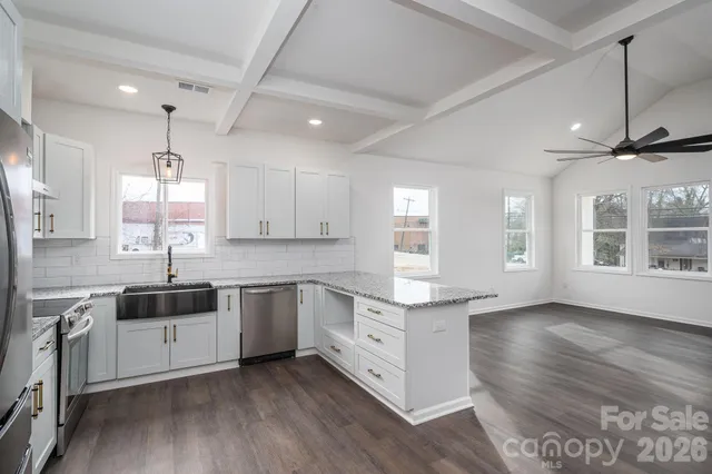 a kitchen with stainless steel appliances granite countertop a refrigerator sink and stove