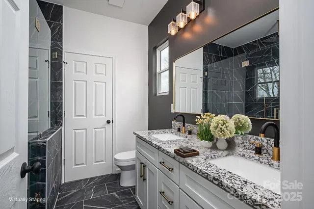 a bathroom with a granite countertop sink toilet and shower