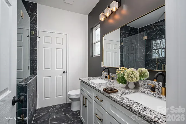 a bathroom with a granite countertop sink toilet and shower