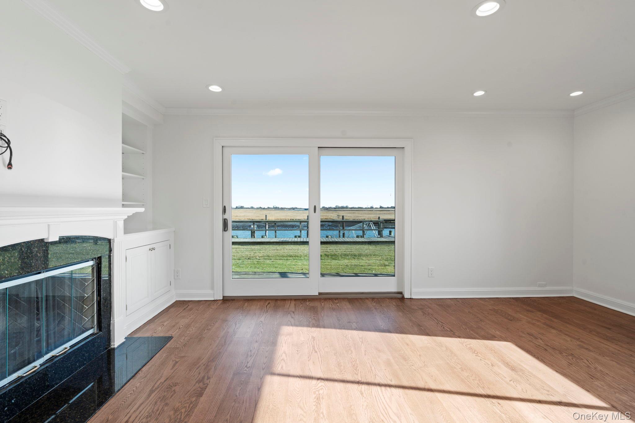 1 Anchorage Way, Unit 101 Freeport, NY 11520 - Photo 3 of 31 a view of empty room with wooden floor and fireplace