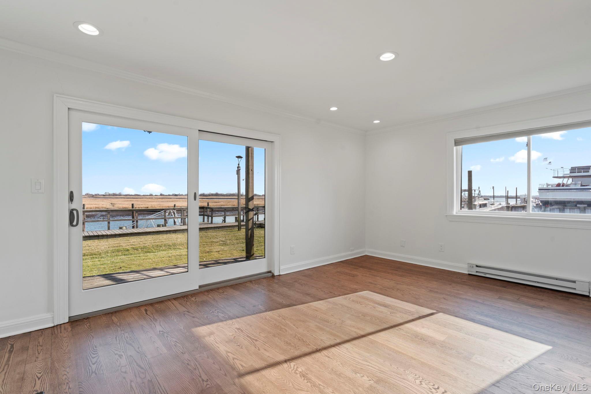 1 Anchorage Way, Unit 101 Freeport, NY 11520 - Photo 4 of 31 wooden floor in an empty room with a window