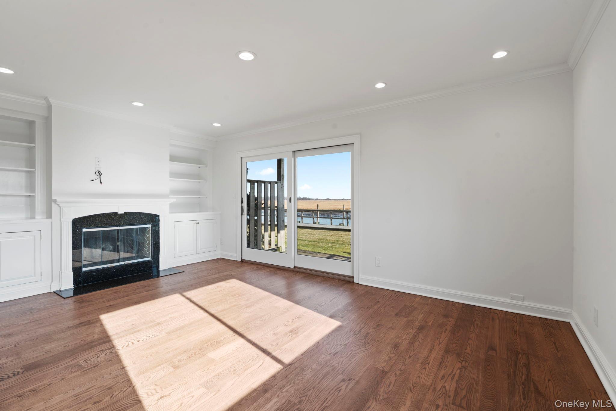 1 Anchorage Way, Unit 101 Freeport, NY 11520 - Photo 6 of 31 a view of an empty room with a fireplace and a window