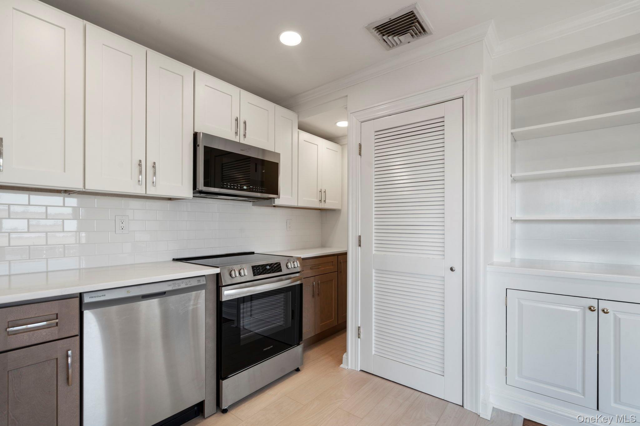 1 Anchorage Way, Unit 101 Freeport, NY 11520 - Photo 7 of 31 a kitchen with stainless steel appliances granite countertop white cabinets and a stove