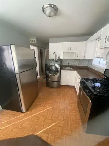 a kitchen with a stove a refrigerator and cabinets