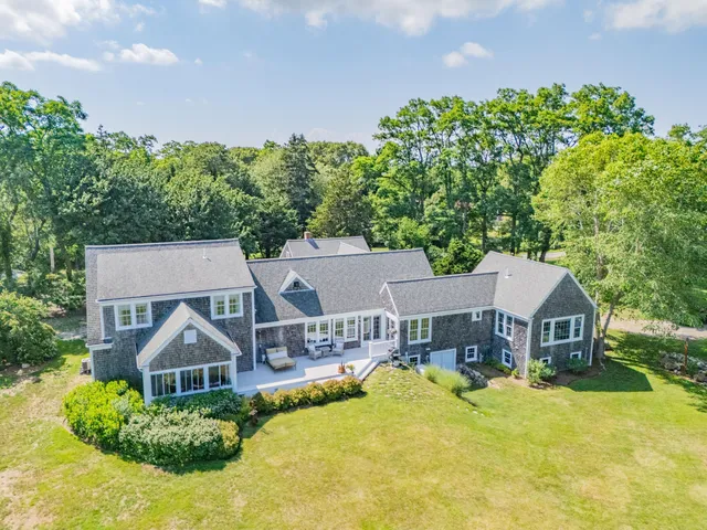 an aerial view of a house with a big yard and large trees