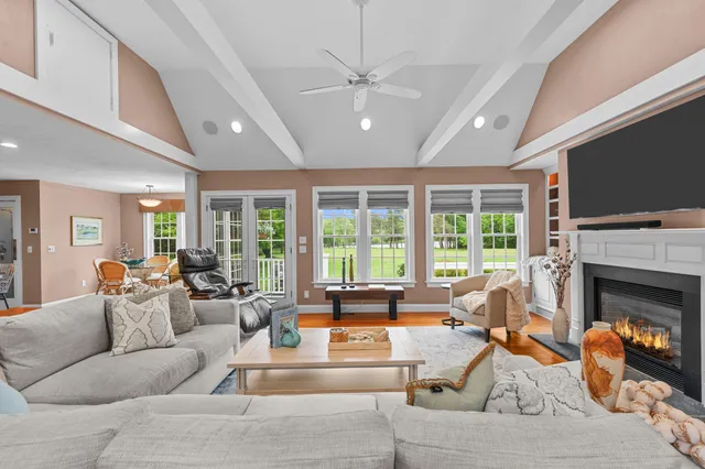 a living room with furniture a fireplace and a flat screen tv