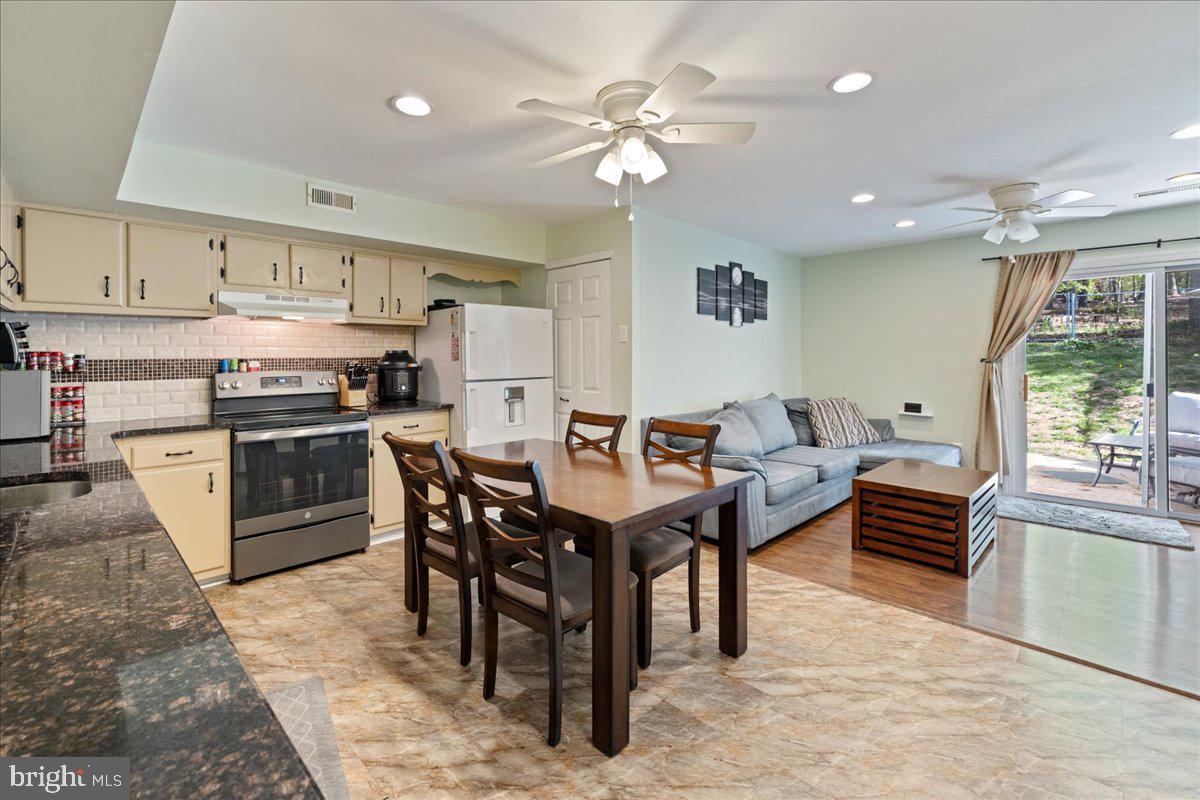 4639 Sands Way Doylestown, PA 18902 - Photo 17 of 32 a kitchen with stainless steel appliances kitchen island granite countertop a table chairs and a refrigerator