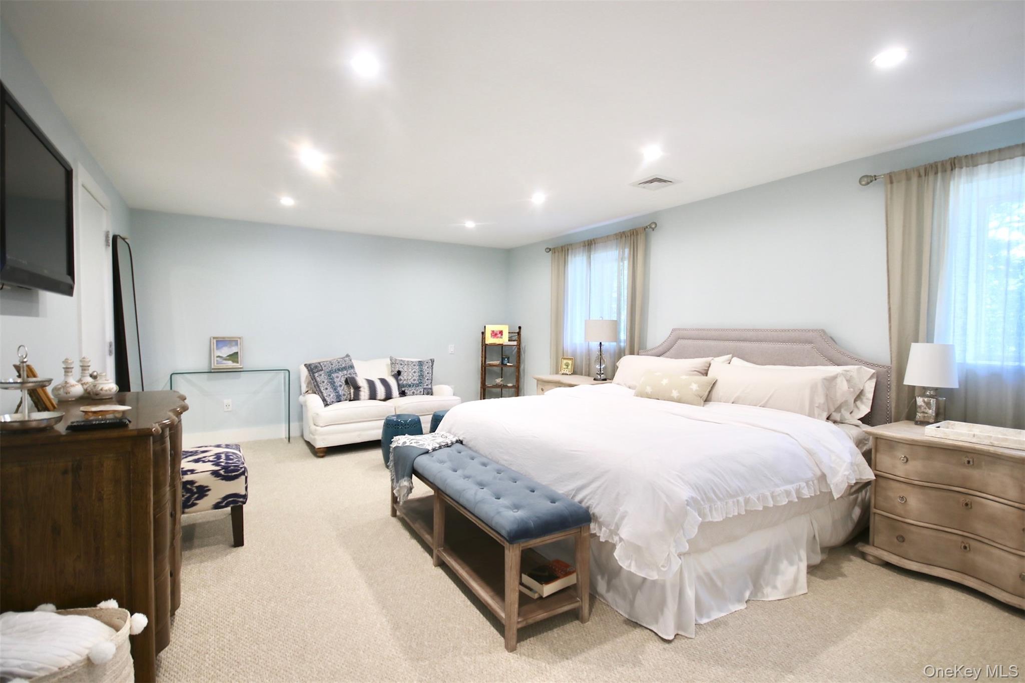 28 Old Trail Road Water Mill, NY 11976 - Photo 12 of 25 a spacious bedroom with a bed and flat screen tv