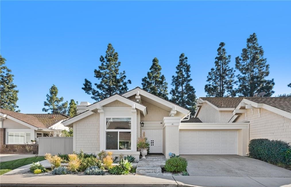 a view of a white house with a yard and potted plants