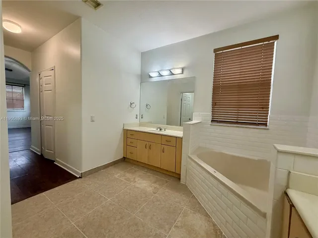 a bathroom with a bathtub sink and mirror