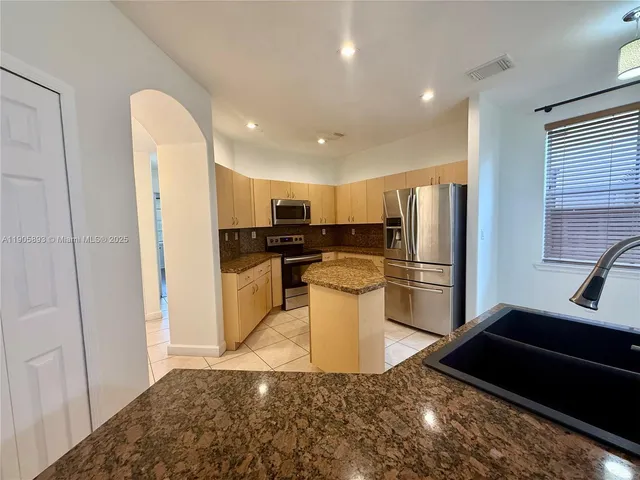 a kitchen with a refrigerator and a sink