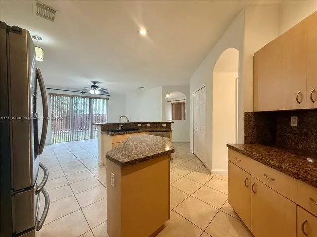 a kitchen with stainless steel appliances granite countertop a sink and a refrigerator