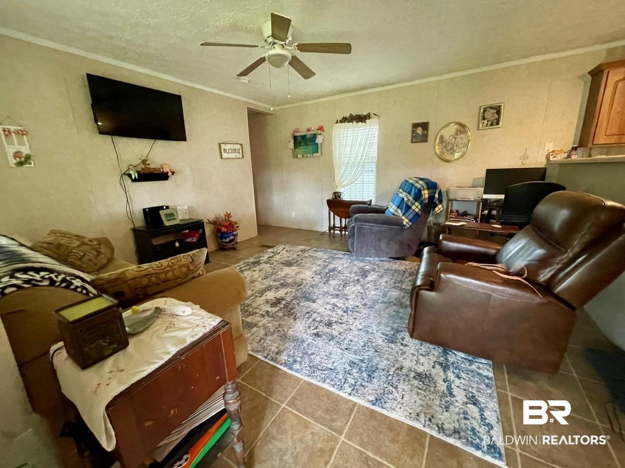 15338 Windbigler Drive Foley, AL 36535 - Photo 8 of 28 Tiled living room featuring ornamental molding, a textured ceiling, and ceiling fan