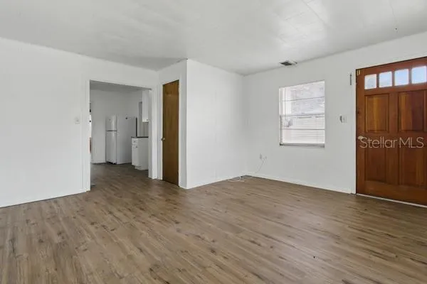 a view of an empty room with closet and a window