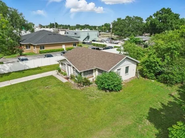 an aerial view of residential houses with yard and trees