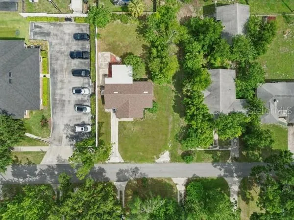 an aerial view of residential house with outdoor space and trees all around