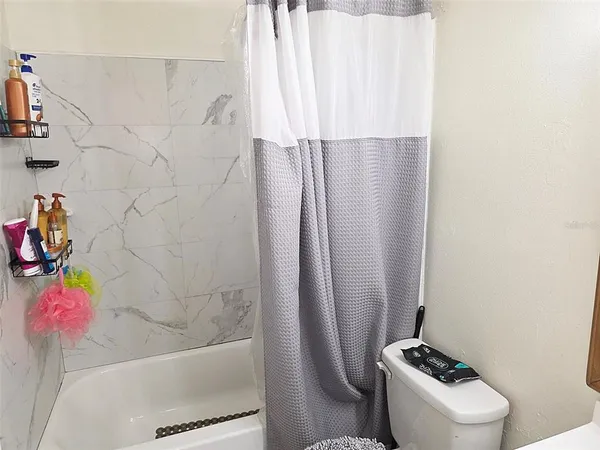 a bathroom with a toilet and a shower curtain