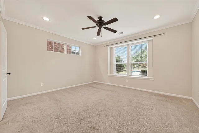 an empty room with window and ceiling fan