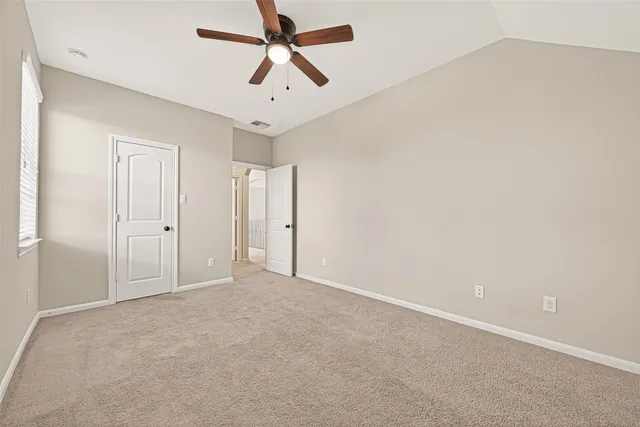 an empty room with chandelier fan