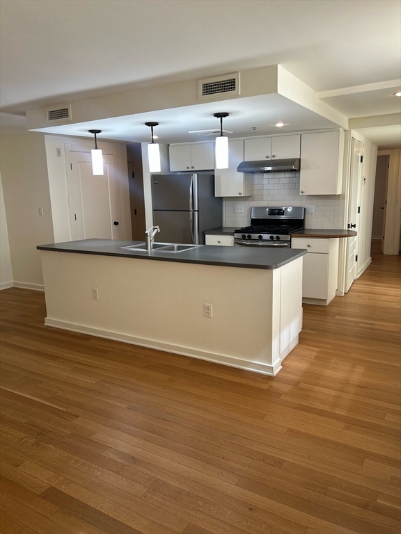 a kitchen with stainless steel appliances a sink and stove top oven