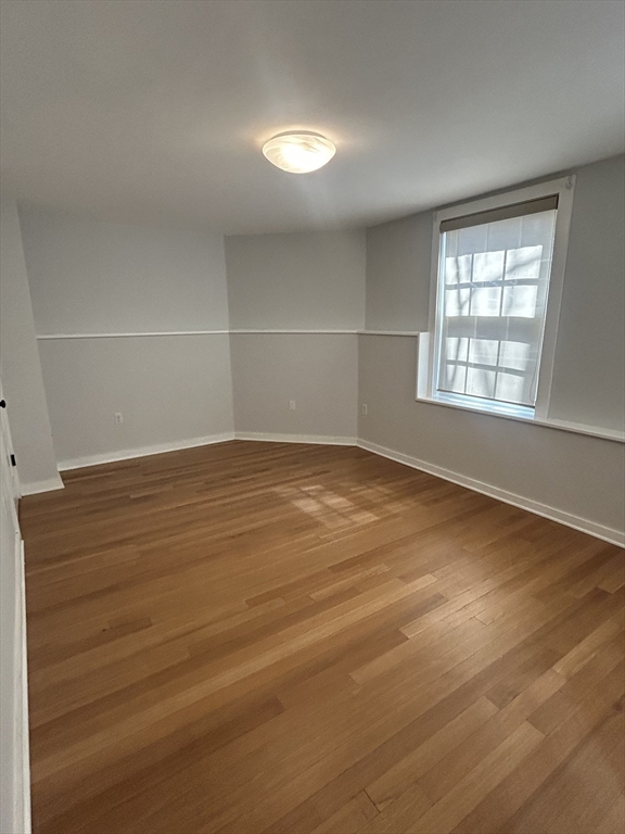 10 Linwood Street, Unit 1 Boston, MA 02119 - Photo 2 of 11 wooden floor in an empty room with a window