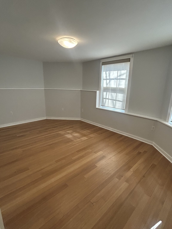10 Linwood Street, Unit 1 Boston, MA 02119 - Photo 4 of 11 an empty room with wooden floor and windows