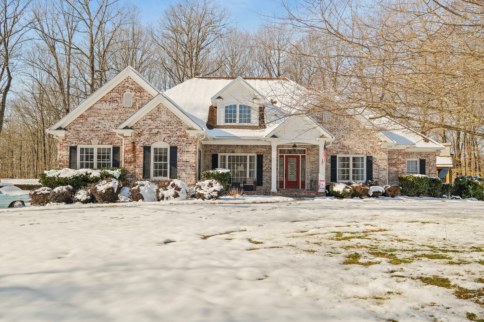 a view of a house with a yard covered in snow