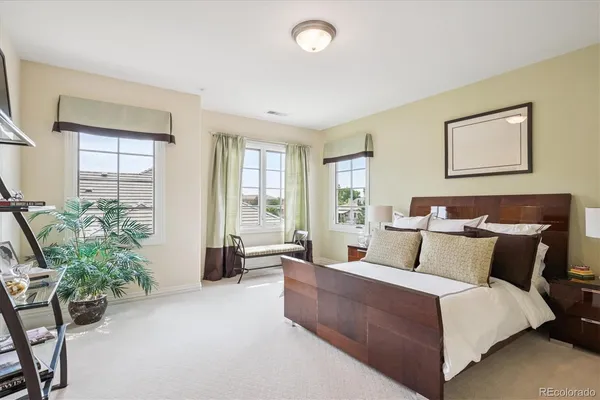 a bedroom with a large bed and windows