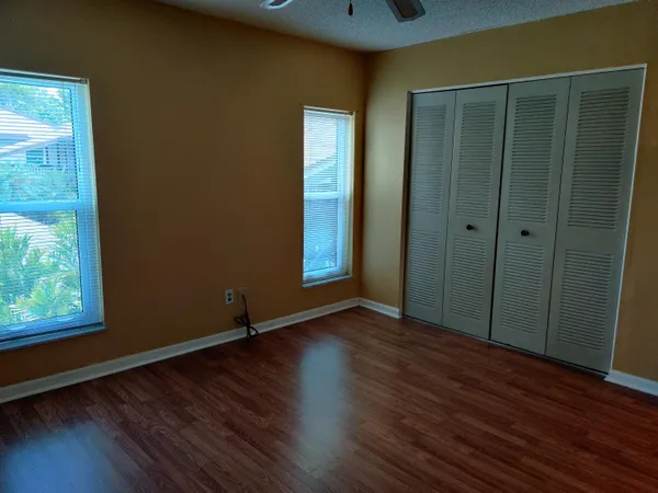 an empty room with wooden floor and windows