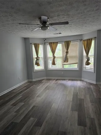 an empty room with wooden floor wooden floor and windows