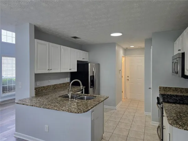 a kitchen with sink a refrigerator and cabinets