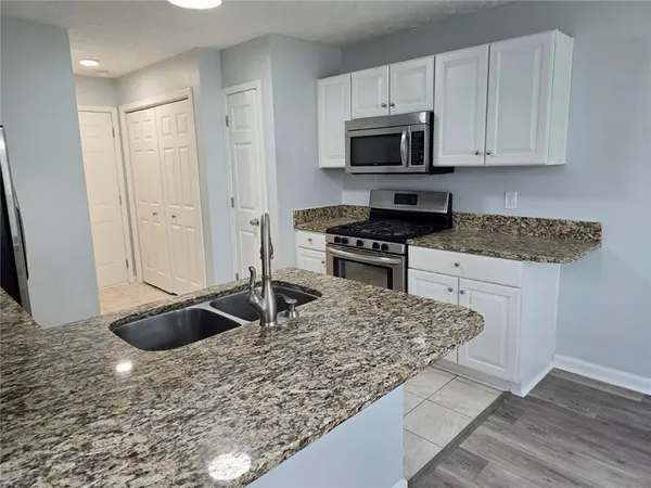 a kitchen with granite countertop a sink and a stove
