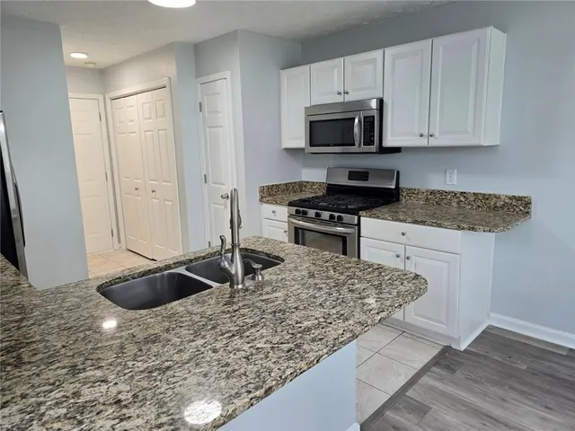 a kitchen with granite countertop a sink and a stove