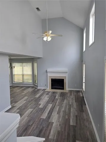 a view of empty room with wooden floor and fireplace