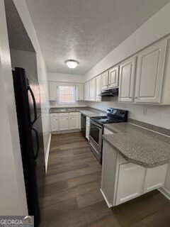122 Saine Drive Southwest, Unit 307 Marietta, GA 30008 - Photo 12 of 22 a kitchen with stainless steel appliances granite countertop a refrigerator a stove a sink dishwasher and a refrigerator with wooden cabinets