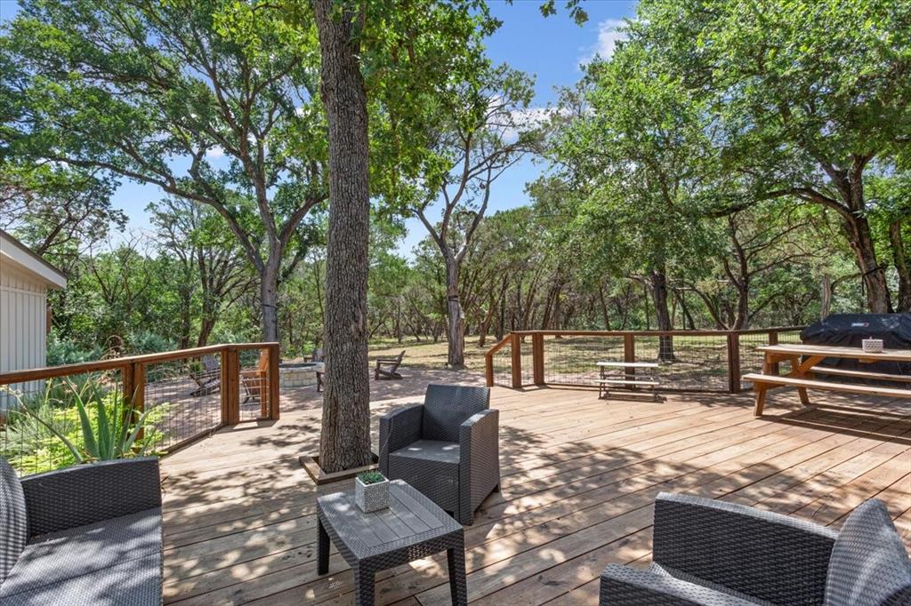 15988 Wortham Bend Road China Spring, TX 76633 - Photo 27 of 40 Spacious wood deck with a natural wood railing and wire infill, surrounded by mature trees