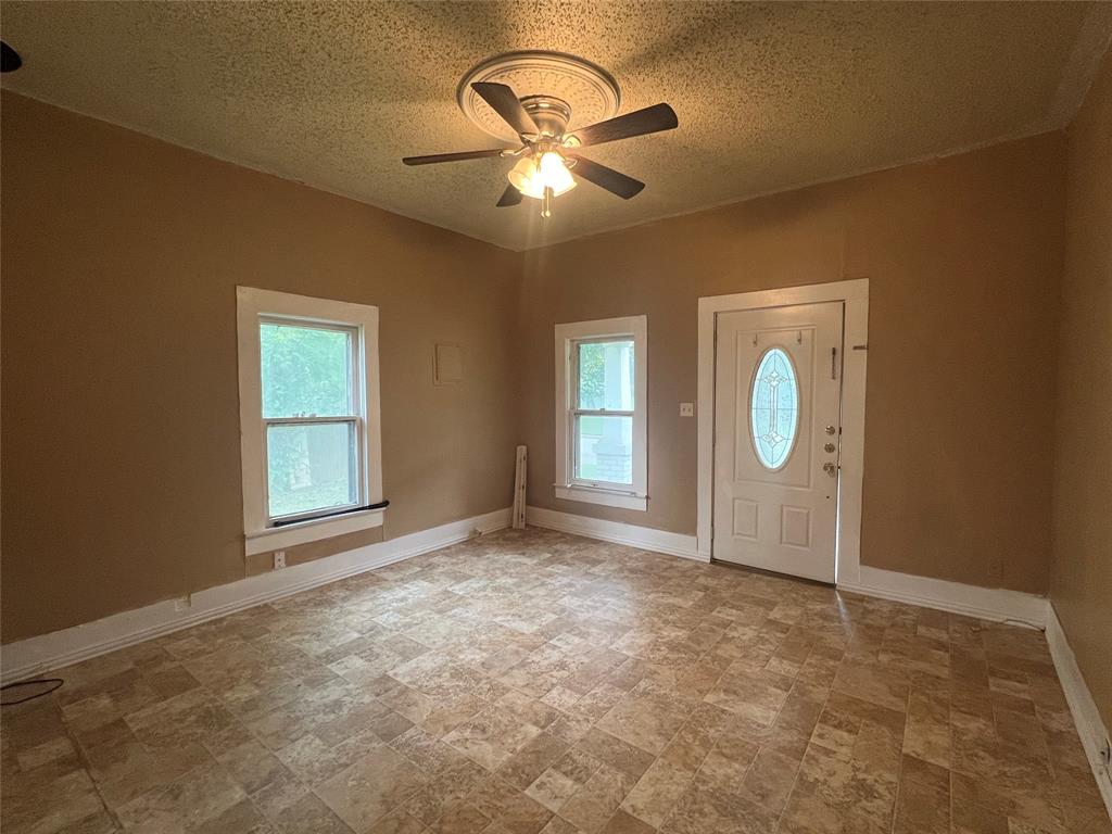 311 West Spring Street Weatherford, TX 76086 - Photo 2 of 15 an empty room with windows and fan