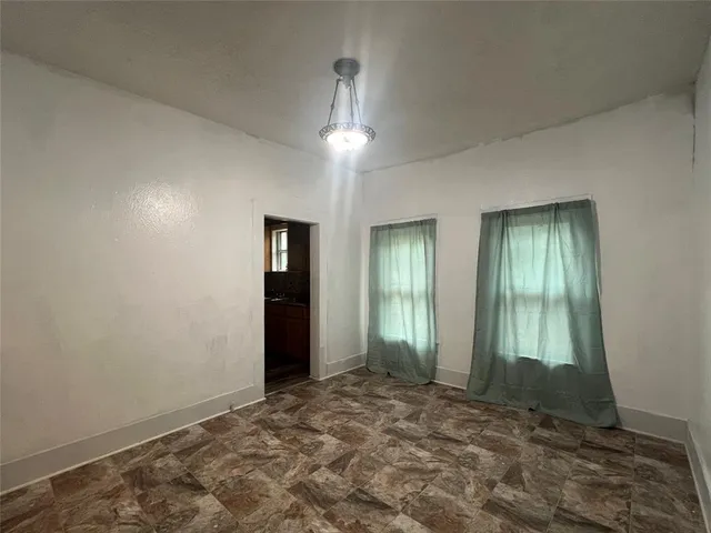 an empty room with closet and windows