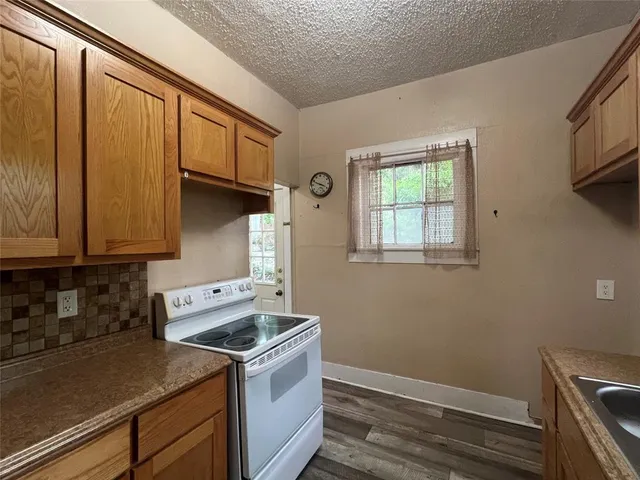 a view of a kitchen with wooden floor and cabinets