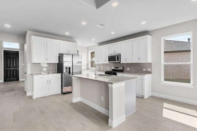 a kitchen with white cabinets and white appliances