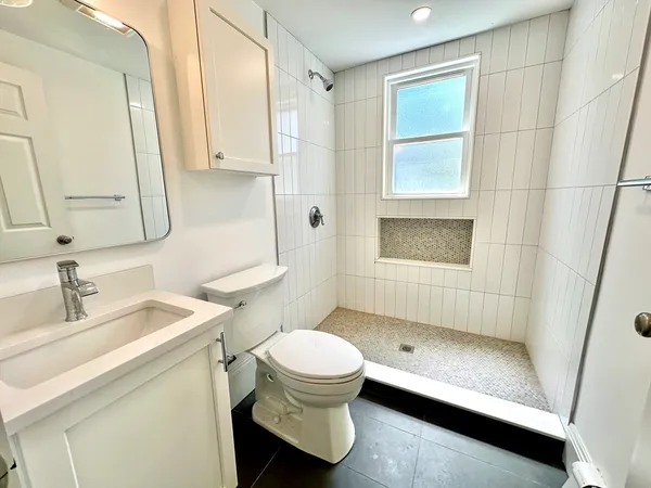 a bathroom with a sink a toilet and shower