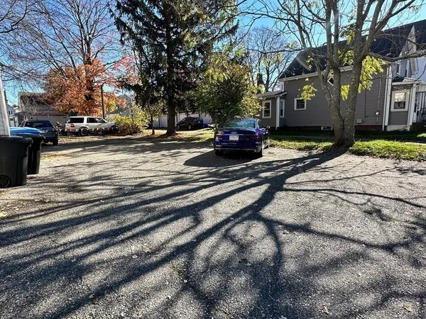 a view of road with card parked on side and road