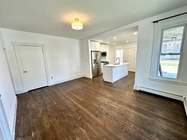 a view of living room with stove and white cabinets