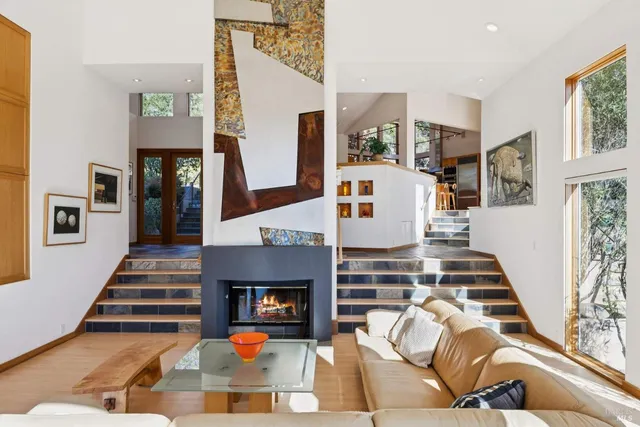 a living room with furniture large window and fireplace