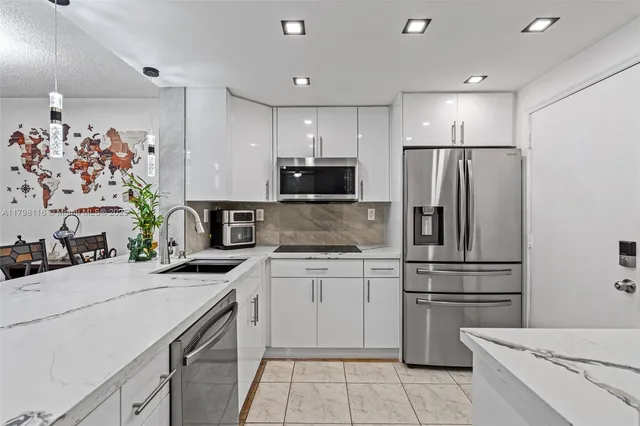 a kitchen with granite countertop a refrigerator and a stove top oven