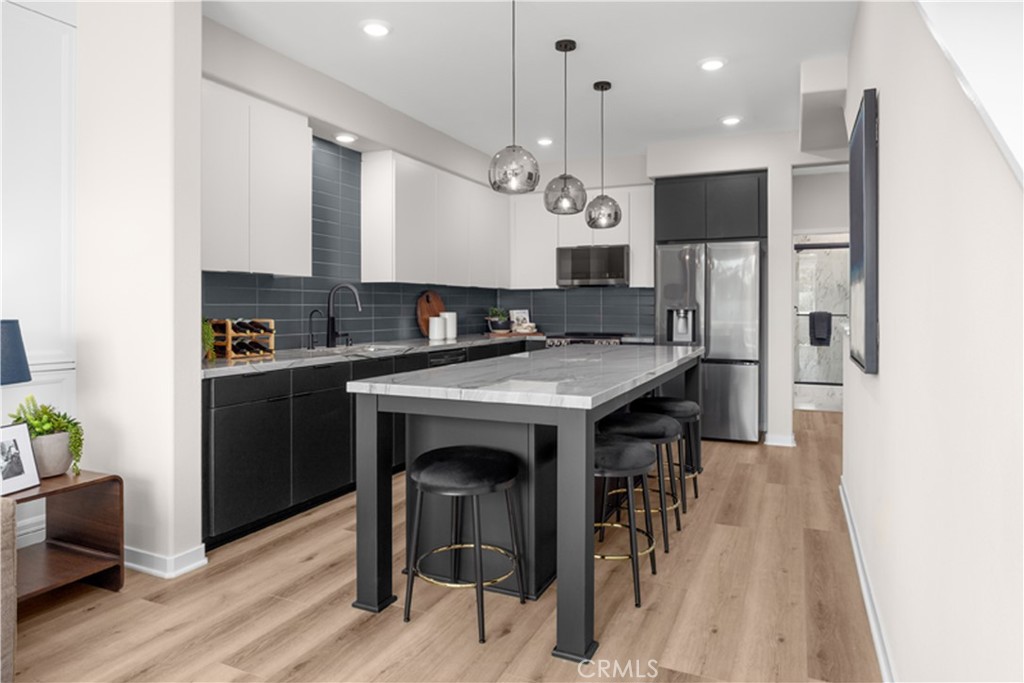 7363 Suva Street Downey, CA 90240 - Photo 5 of 13 a kitchen with a sink a microwave a stove and chairs