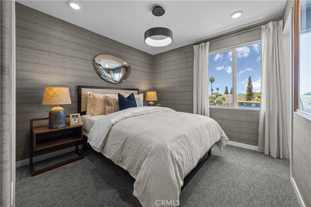 7363 Suva Street Downey, CA 90240 - Photo 10 of 13 a bedroom with a bed and a lamp on dresser next to a window